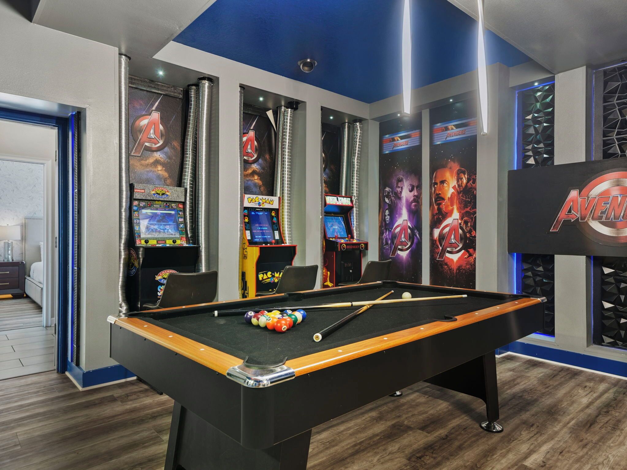 Een biljarttafel met diverse spelautomaten en posters op de achtergrond.