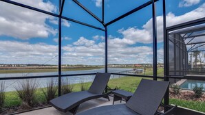 A balcony with two lounge chairs and a view of a river and distant landscape. - Beautiful Home W/private Pool & Spa, Near Wdw! (Kissimmee)