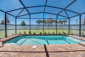 An indoor swimming pool with a clear view of palm trees and a fenced area. - Large Villa W/private Pool & Game Room! Waterpark (Kissimmee)