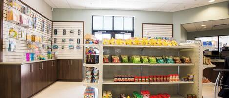 A grocery store interior with shelves stocked with snacks, condiments, and household items.