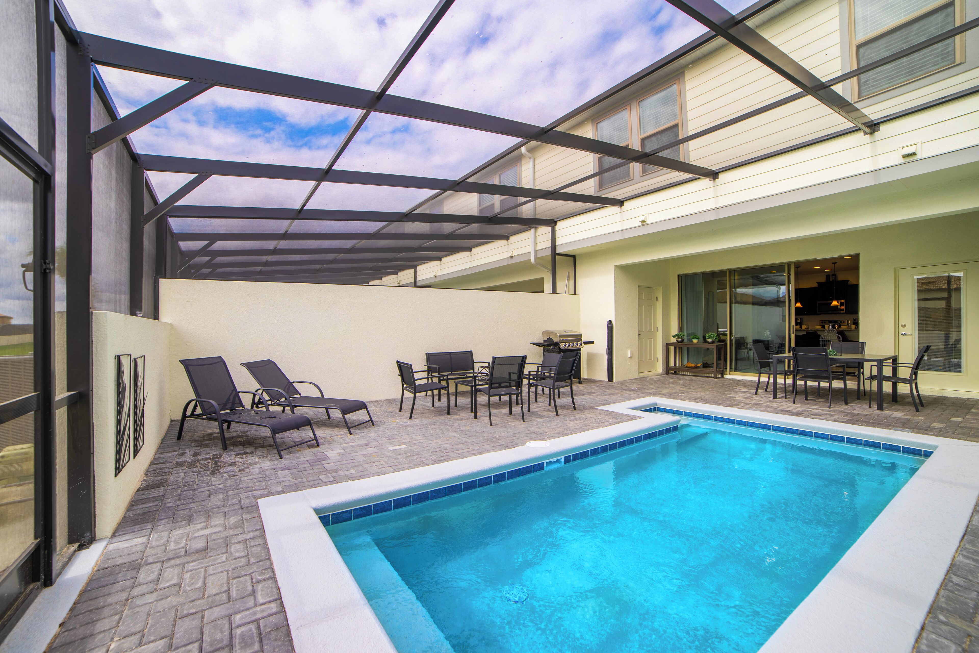 Une piscine extérieure avec des chaises longues et un espace patio.