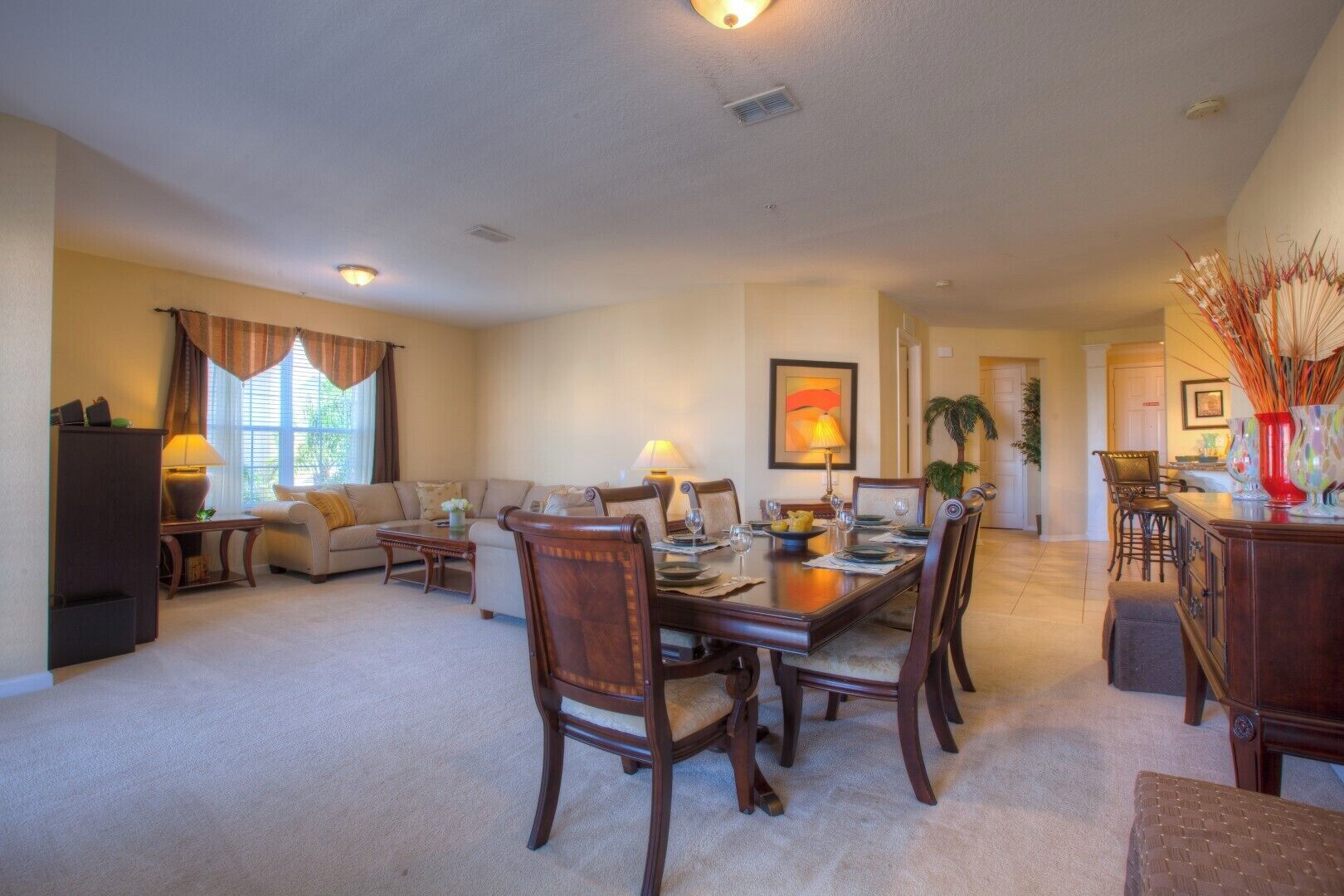 A spacious living room with a dining area, featuring a large wooden table and comfortable seating.