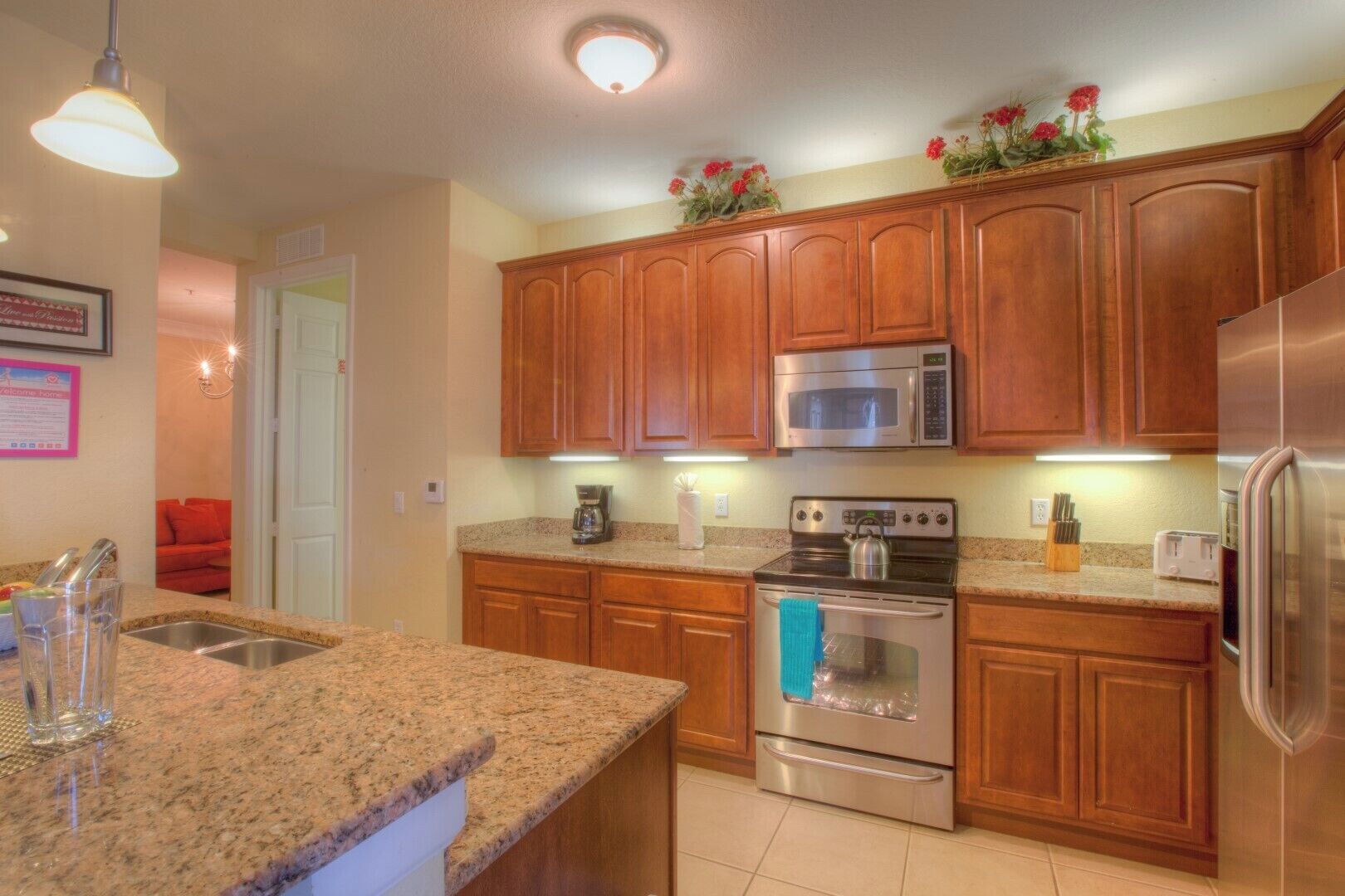 A kitchen with granite countertops, wooden cabinets, stainless steel appliances, and a built-in oven.