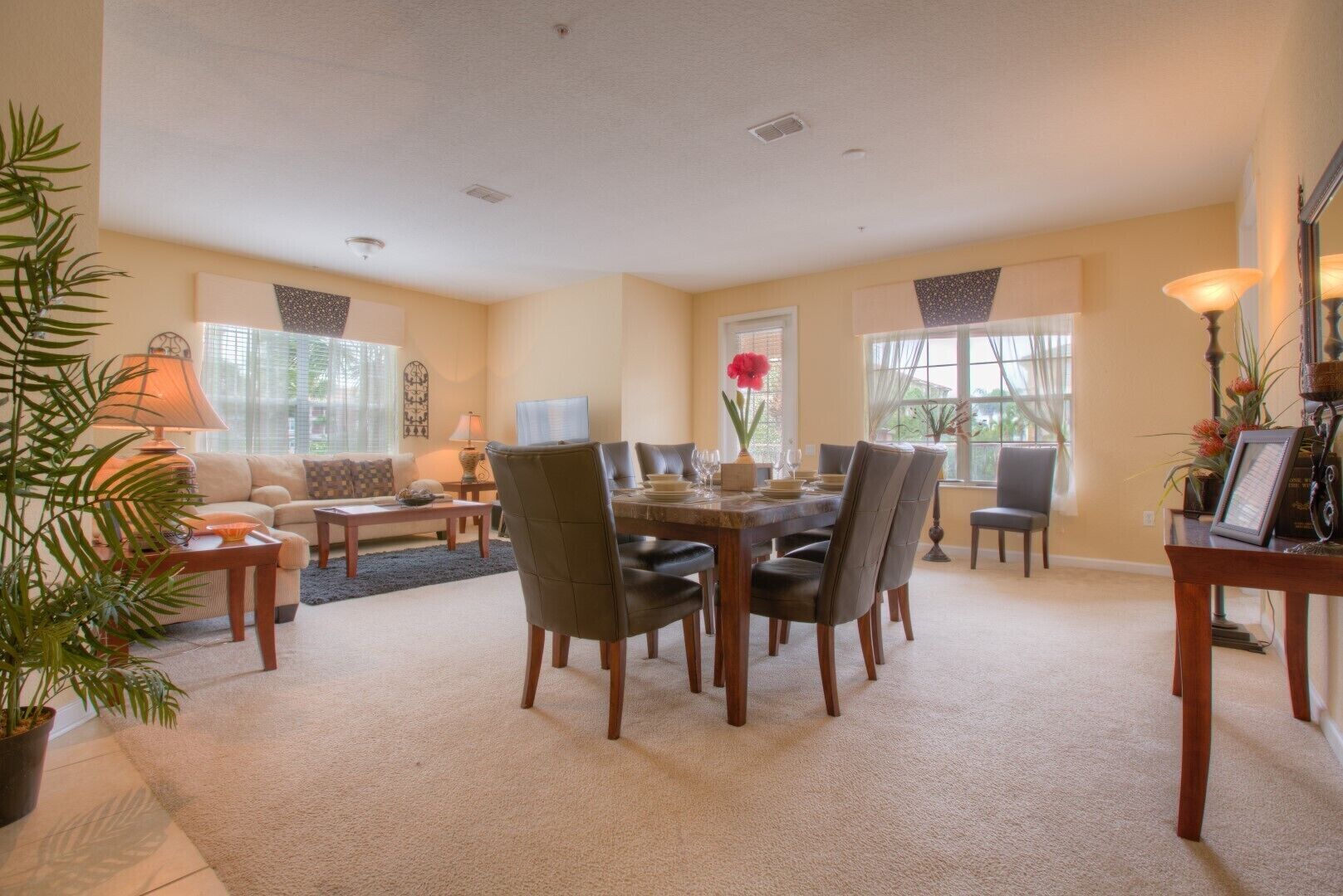 A spacious living room with a dining area, large windows, and a cozy fireplace.