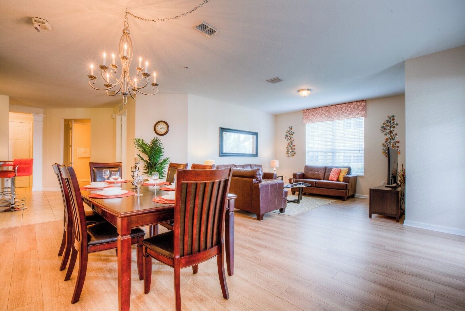 A spacious living area with a dining table, chairs, a sofa, and a television.