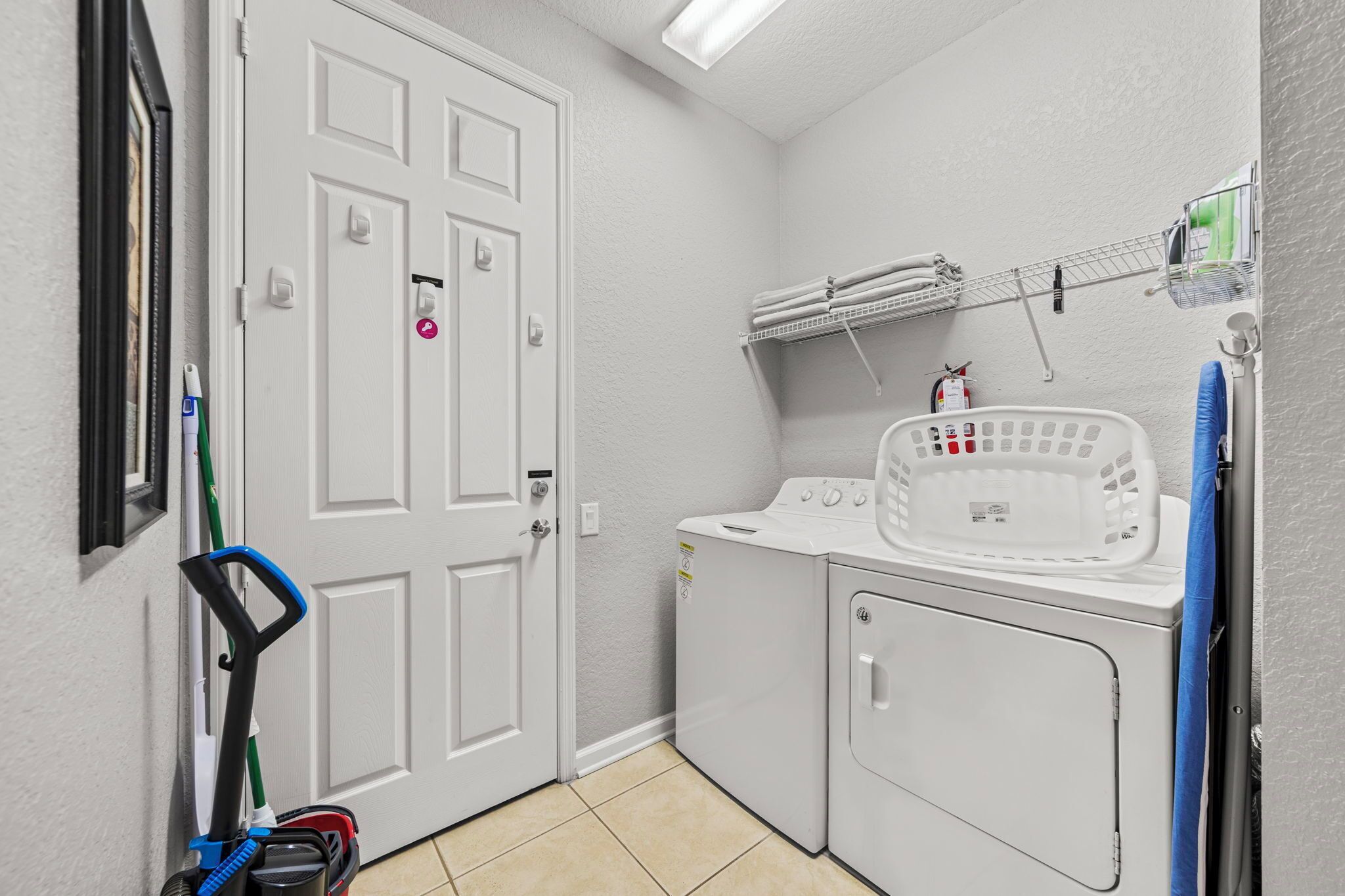 A laundry area with a washing machine, dryer, and a wall-mounted drying rack.