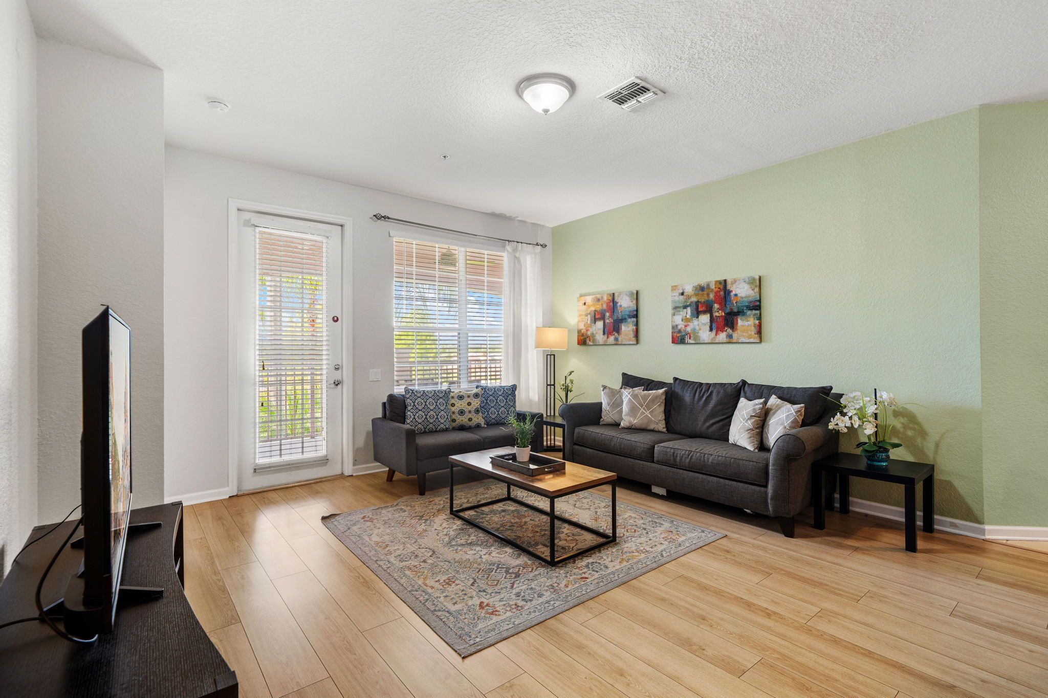 A living room with a sofa, coffee table, and artwork on the wall.
