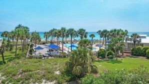 Un resort con piscina, palmeras y vista al océano.