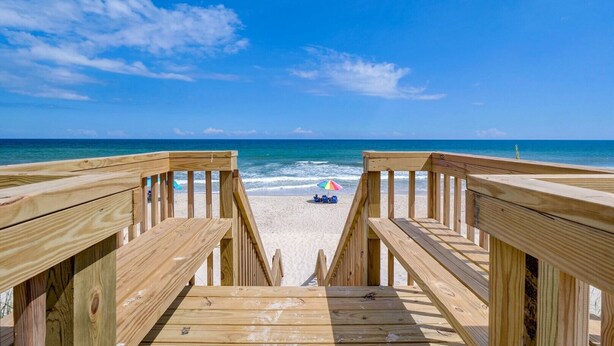 A wooden boardwalk leading to a sandy beach with a clear blue sky and ocean in the background. - 3800 Island Drive- Pet Friendly, Direct Oceanfront with Amazing Oceanview's from 2 decks- Adjoini... (North Topsail Beach)
