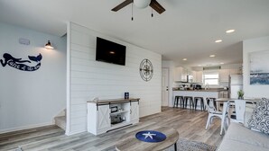 A modern kitchen with white cabinetry, a central island, and a dining area with a round table and bar stools. - 3800 Island Drive- Pet Friendly, Direct Oceanfront with Amazing Oceanview's from 2 decks- Adjoini... (North Topsail Beach)