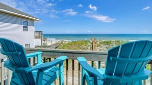 A wooden deck with turquoise Adirondack chairs overlooking a beach. - 3800 Island Drive- Pet Friendly, Direct Oceanfront with Amazing Oceanview's from 2 decks- Adjoini... (North Topsail Beach)