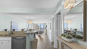 A modern kitchen with a central island, wooden cabinets, and a view to the dining area.