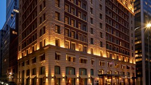 A large, historic building with multiple floors and a classic architectural style, featuring ornate detailing and large windows. - The Wall Street Hotel (New York)