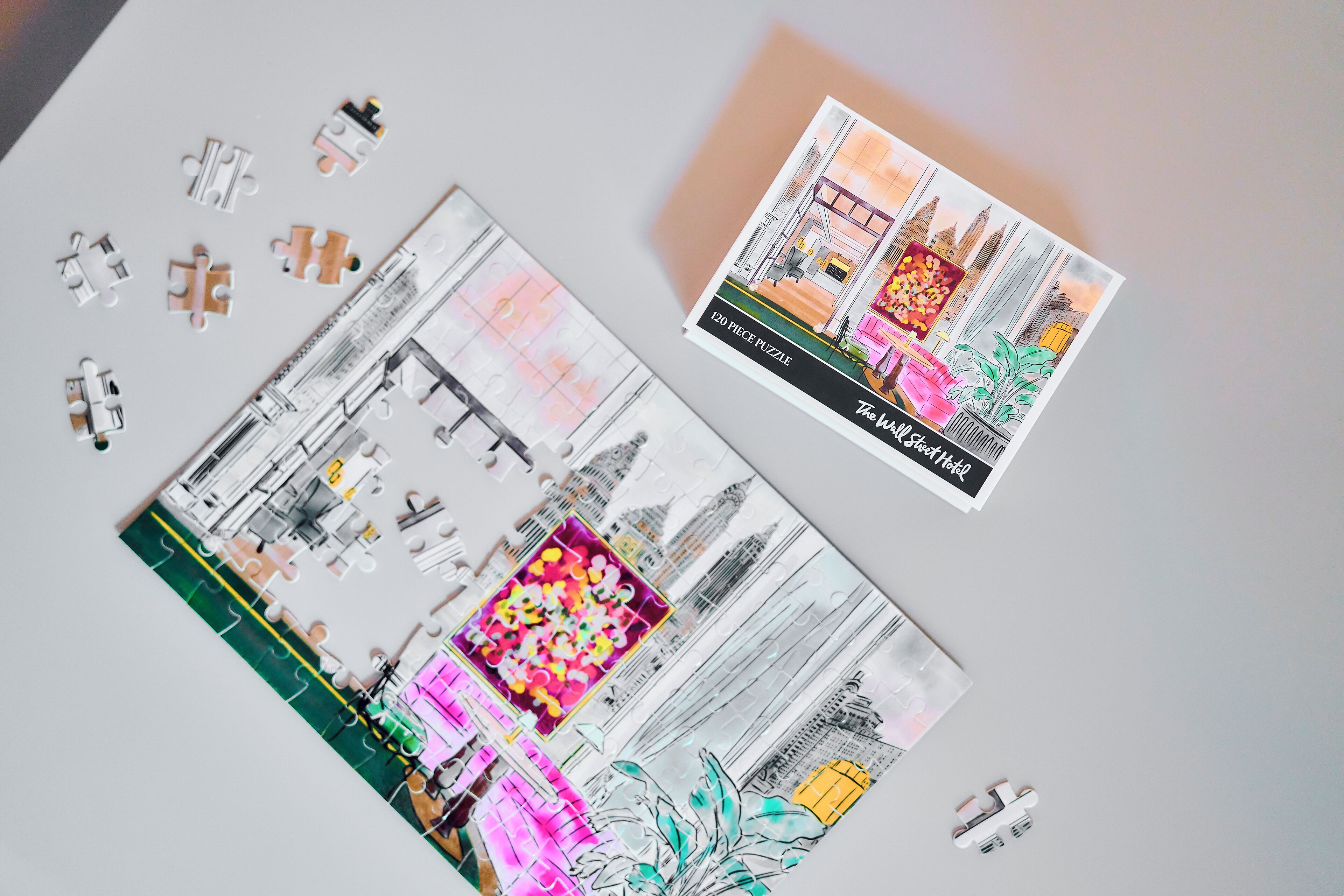 A puzzle piece layout of a hotel interior with a large central floral area and a view of a cityscape.