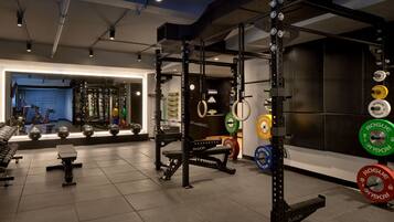 A gym with weightlifting equipment, including a squat rack and various weight plates.