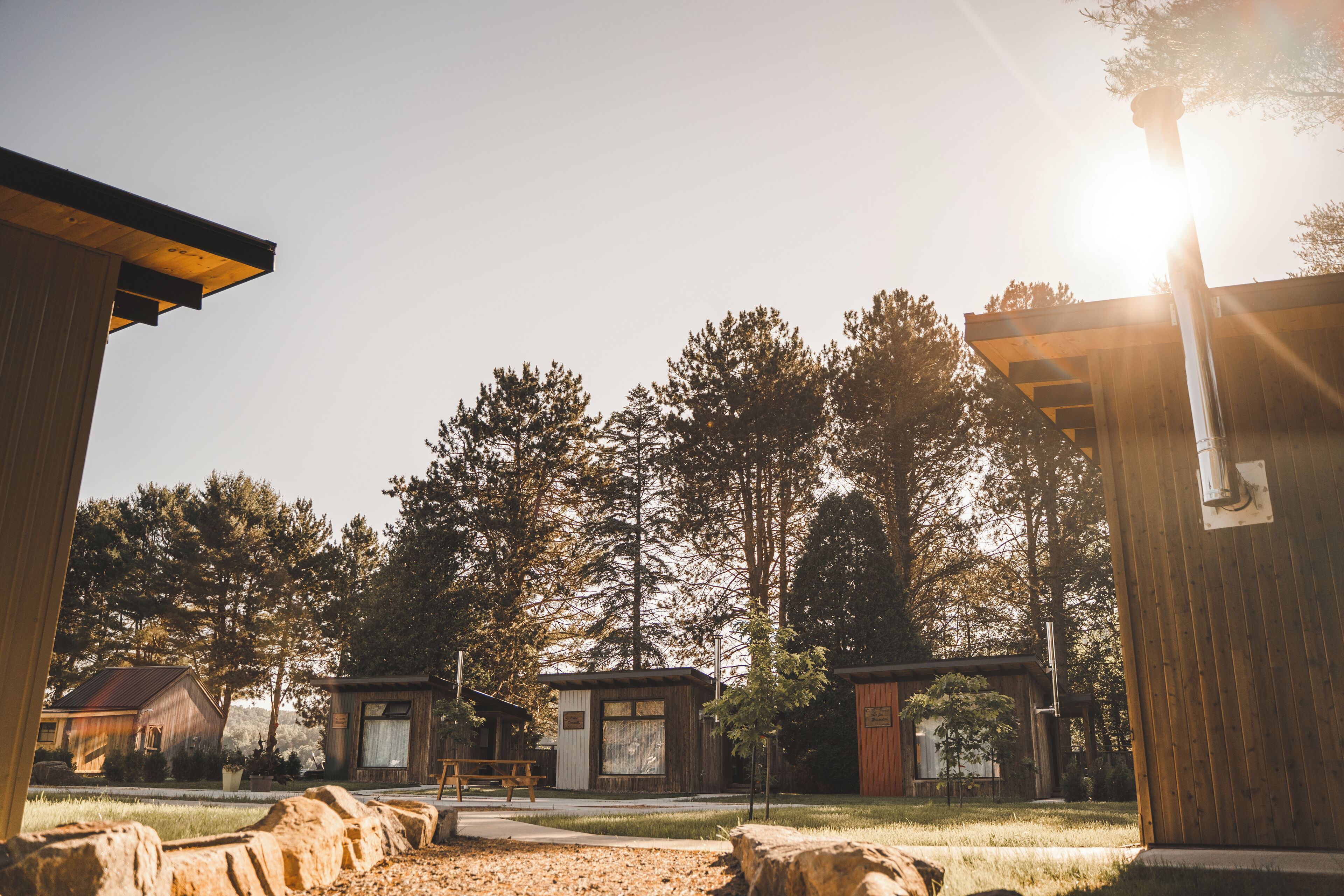 A rustic cabin-style building with a wooden exterior, a picnic table, and a well-maintained lawn.