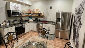 A modern kitchen with a central island, stainless steel appliances, and decorative wall art. - Close by downtown Asheville, the Biltmore Estate, Blue Ridge ParkWay, Arboretum. (Candler)