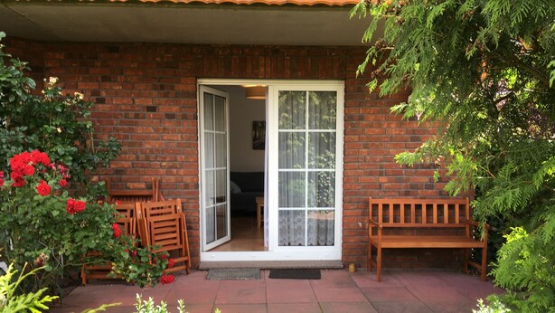 Un edificio de ladrillo con un banco y una mesa en el exterior.