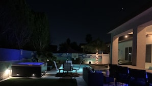 An outdoor patio with a hot tub, seating area, and a pool. - Wildflower Ranch Backyard Oasis with Pool & Spa (Goodyear)
