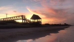Una playa con una estructura de madera y un puente.