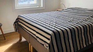 Une chambre avec un lit, une fenêtre donnant sur un port de plaisance et un plancher en bois.