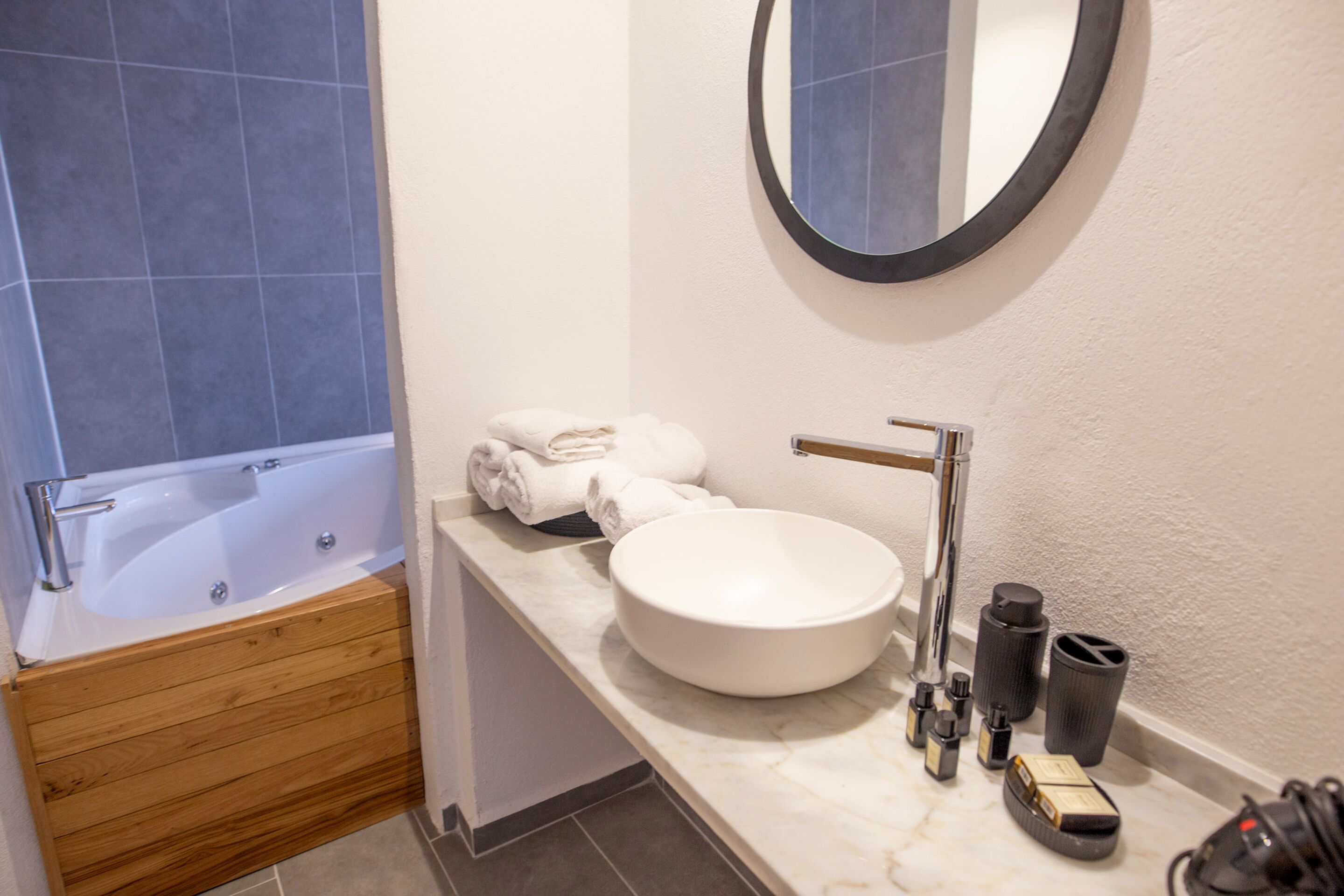 Ein modernes Badezimmer mit Badewanne, großem Waschbecken und Spiegel.