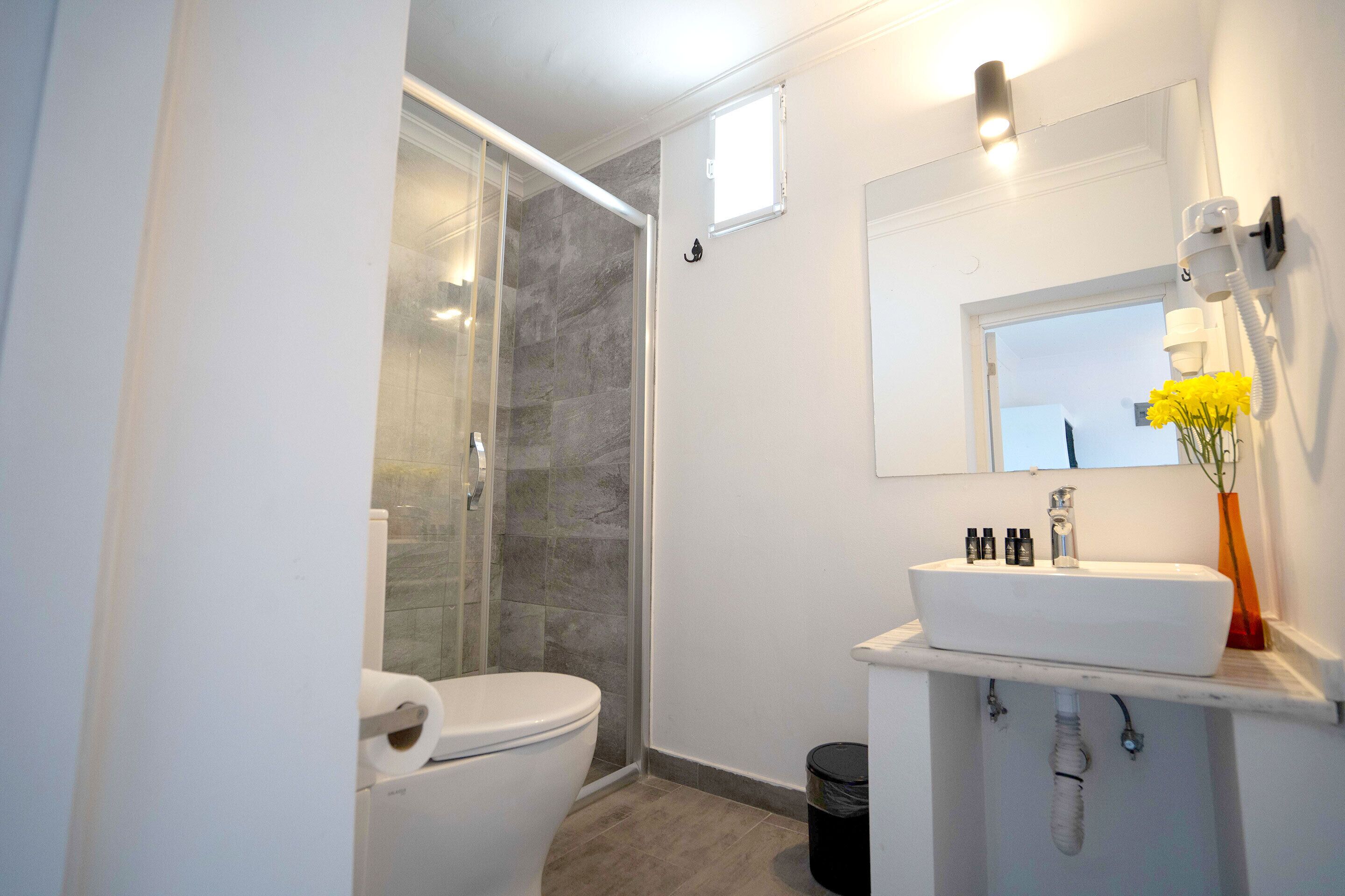 A modern bathroom with a toilet, shower, and sink.