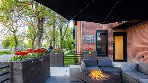 An outdoor seating area with a fire pit, a covered patio, and a brick building with a sign that reads "503". - *Downtown Luxury + Outdoor Patio*~ Walk Everywhere (Bozeman)