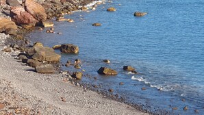 Un rivage rocheux bordé d’une eau d’un bleu limpide.