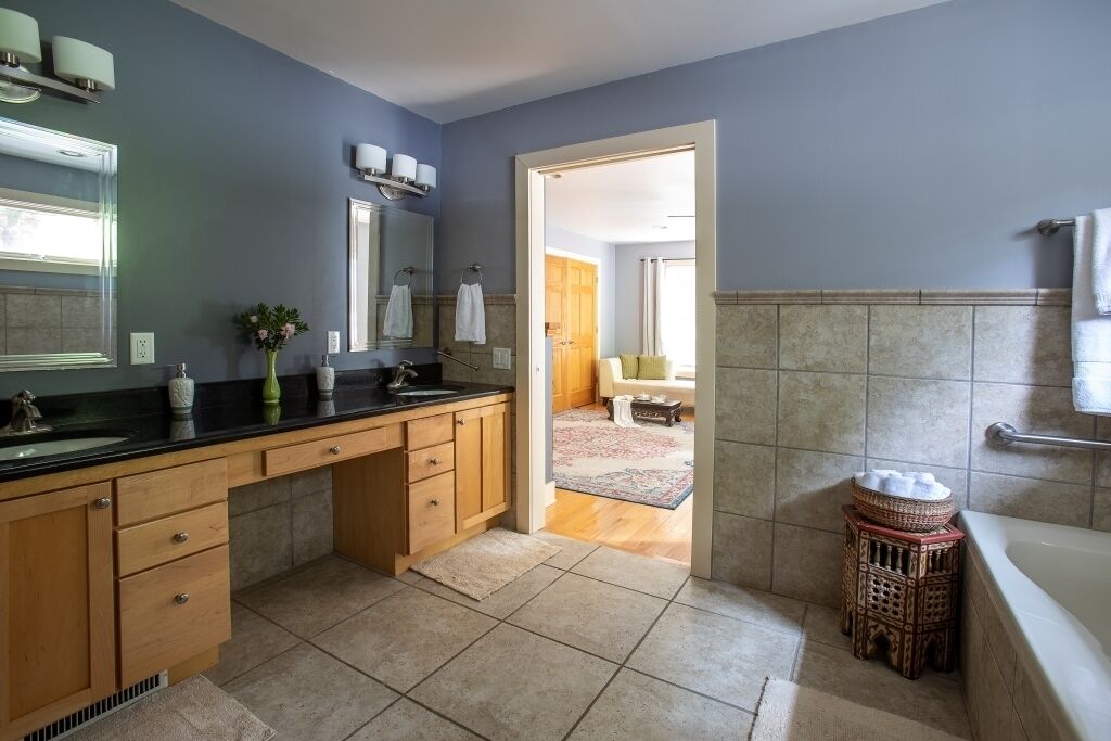 A modern bathroom with a large sink, vanity, and bathtub.