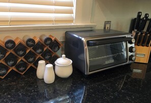 A kitchen with a toaster oven, salt shakers, and a spice rack. - Waterfront Historic Bungalow Three• Ferry to SF (Vallejo)