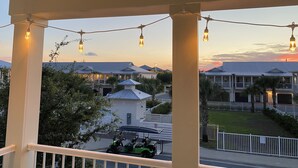 A covered porch with string lights, a golf cart, and a view of residential buildings. - Seasonal Beach Service & Heated Pool + Golf Cart Included!! (Destin)