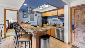 A modern kitchen with granite countertops, stainless steel appliances, and wooden cabinets.