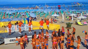 Una playa con un escenario y artistas.