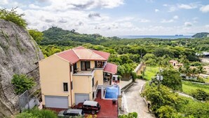 Una casa de dos pisos con techo rojo, garaje y entrada para coches.