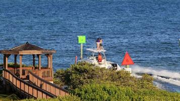 A wooden gazebo overlooking a body of water, a small boat with a person on it, and a red triangular sign with the number 6.
