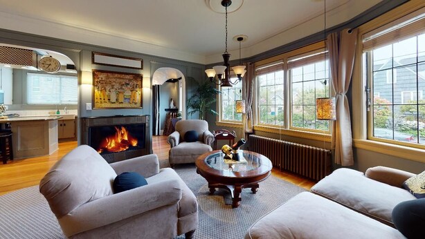 A spacious living room with a fireplace, comfortable seating, and large windows offering a view of the outside. - Lower Suite: a classic suite in a quiet Seattle home (Seattle)
