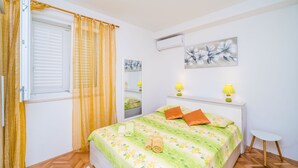 A bedroom with a bed, two bedside lamps, a window with curtains, and a wall-mounted air conditioner. - Rooms Rita - Double Room with Private Bathroom (No. 2) (Dubrovnik)