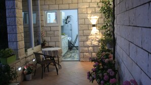 A small patio with a table and chairs, surrounded by potted plants and flowers. - Rooms Rita - Double Room with Private Bathroom (No. 2) (Dubrovnik)