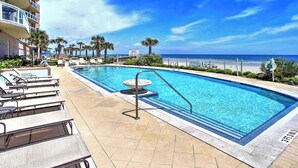 Une piscine avec des chaises longues et vue sur l’océan.