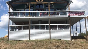 A multi-story building with a balcony on the upper floor, featuring a sign that reads "LIVING ON THE EDGE". - Livin on the Edge on the Caddo River (Glenwood)