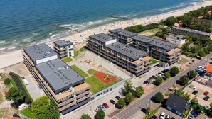 Un hotel costero con varias edificaciones, una playa y un parque infantil.