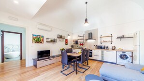 Um apartamento moderno com área de jantar, cozinha e sala de estar.