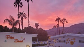 Ett poolområde vid ett semesterhotell med utomhusmöbler och en skylt med texten ”Palm Desert”.