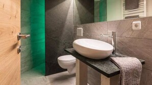 Une salle de bain moderne avec un lavabo blanc, une serviette et des toilettes.