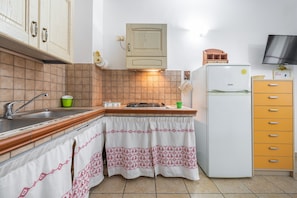 Une cuisine équipée d’un évier, d’une cuisinière et d’un réfrigérateur.