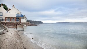 A coastal building with a stone staircase leading to a sandy beach. - Birdcage Cottage- Woodburner & Free Wi-Fi (Kingsand)