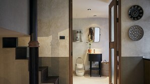 Een moderne badkamer met een wastafel, spiegel en decoratieve borden aan de muur.