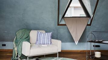 A modern living room with a sofa, a geometric wall decoration, and a patterned rug.
