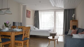 Een moderne woonkamer met een eethoek, een bed en een kleine tafel met een kom.